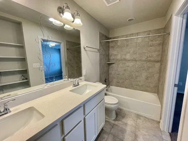 a bathroom with a sink a toilet a mirror and shower