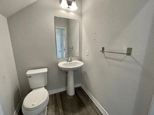 a bathroom with a toilet a sink and mirror