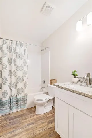 a bathroom with a granite countertop sink a toilet and a mirror