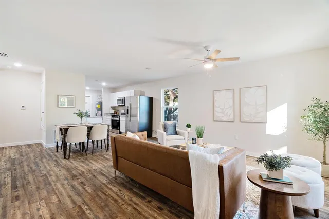 a living room with furniture a dining table and a potted plant