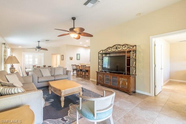 8623 Erice Court Naples, FL 34114 - Photo 17 of 37 a living room with furniture a flat screen tv and kitchen view