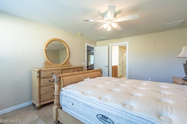 8623 Erice Court Naples, FL 34114 - Photo 20 of 37 a bedroom with a bed a dresser and potted plants