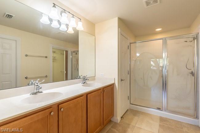 8623 Erice Court Naples, FL 34114 - Photo 21 of 37 a bathroom with a double vanity sink mirror and shower