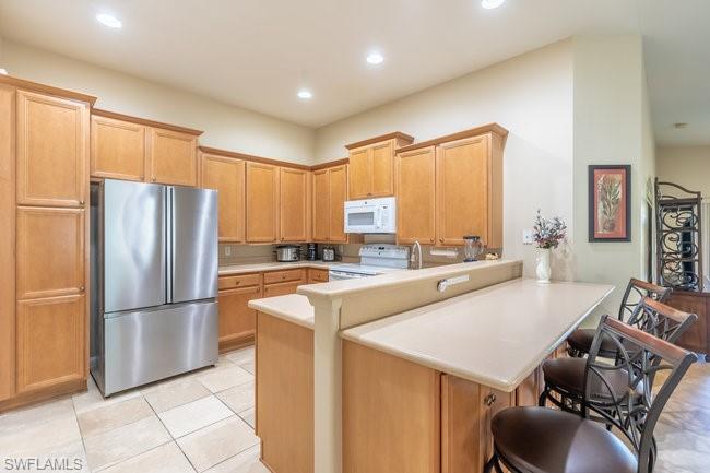 8623 Erice Court Naples, FL 34114 - Photo 8 of 37 a kitchen with stainless steel appliances a refrigerator and a stove top oven