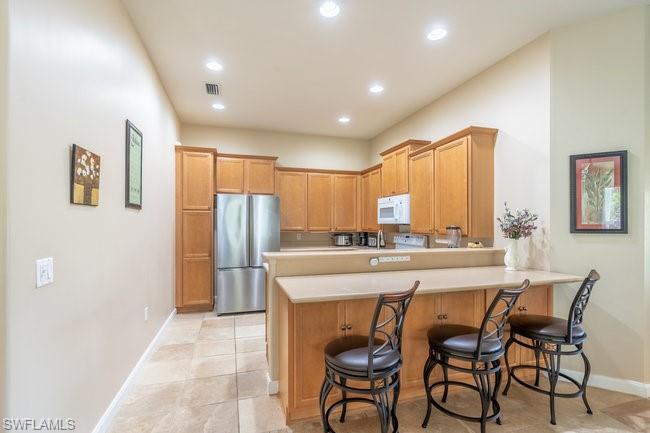 8623 Erice Court Naples, FL 34114 - Photo 9 of 37 a kitchen with stainless steel appliances granite countertop a stove a sink a refrigerator and chairs
