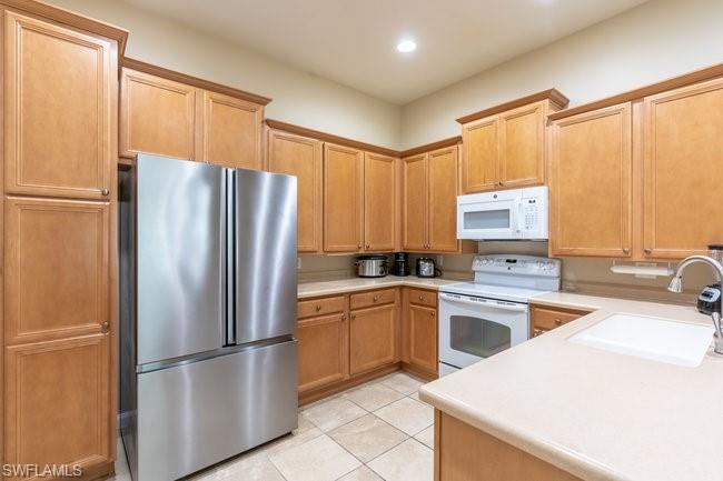 8623 Erice Court Naples, FL 34114 - Photo 10 of 37 a kitchen with a refrigerator a sink and cabinets