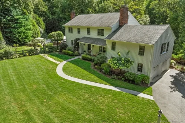 a aerial view of a house with a yard table and chairs