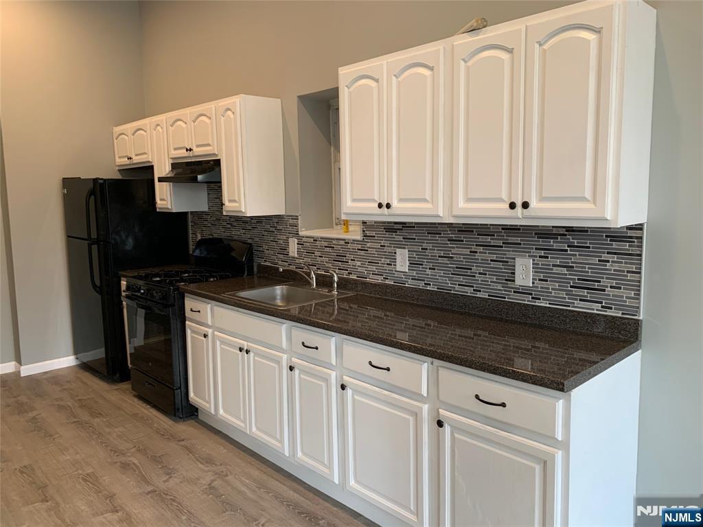 a kitchen with granite countertop white cabinets and sink