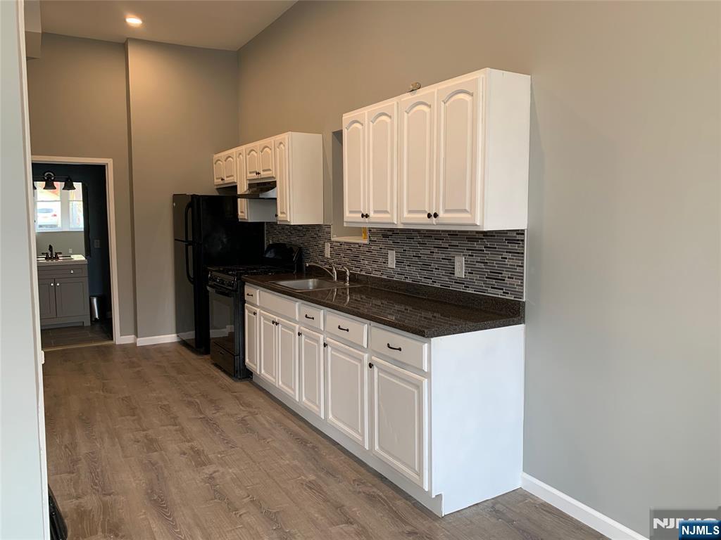 128 Locust Avenue, Unit A Wallington, NJ 07057 - Photo 2 of 13 a kitchen with granite countertop white cabinets and stainless steel appliances