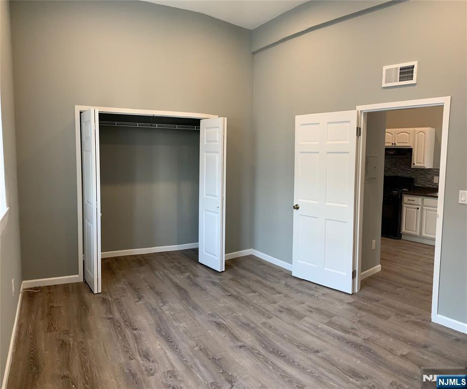128 Locust Avenue, Unit A Wallington, NJ 07057 - Photo 5 of 13 an empty room with wooden floor and closet