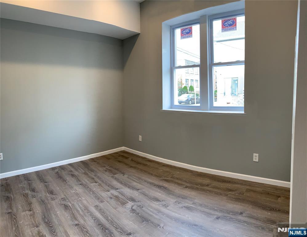 128 Locust Avenue, Unit A Wallington, NJ 07057 - Photo 7 of 13 an empty room with wooden floor and windows