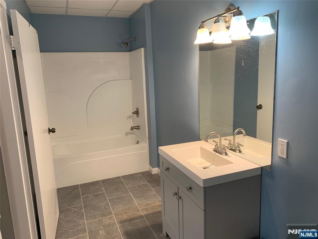 128 Locust Avenue, Unit A Wallington, NJ 07057 - Photo 9 of 13 a bathroom with a sink a mirror and a bathtub