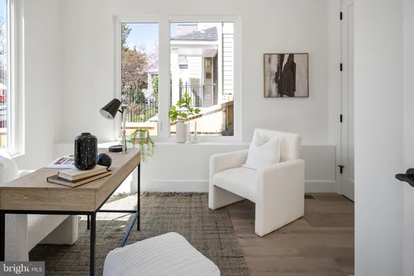 a living room with furniture a desk and chair with windows