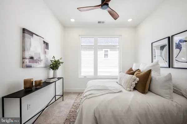 a large bed sitting in a bedroom next to a window and a chandelier