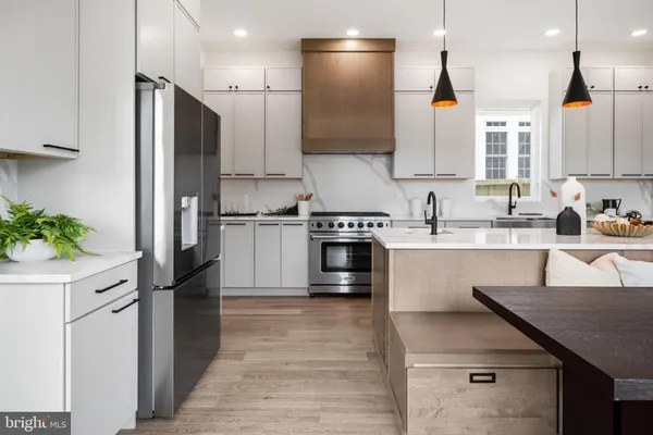 a kitchen with stainless steel appliances granite countertop a refrigerator a sink and a stove