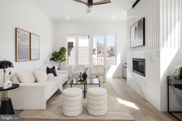 a living room with furniture a flat screen tv and a large window