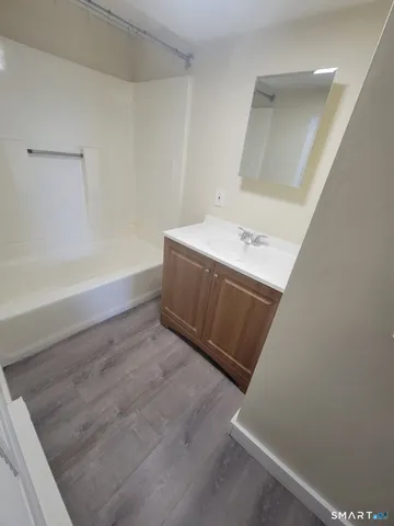 a bathroom with a tub sink and vanity