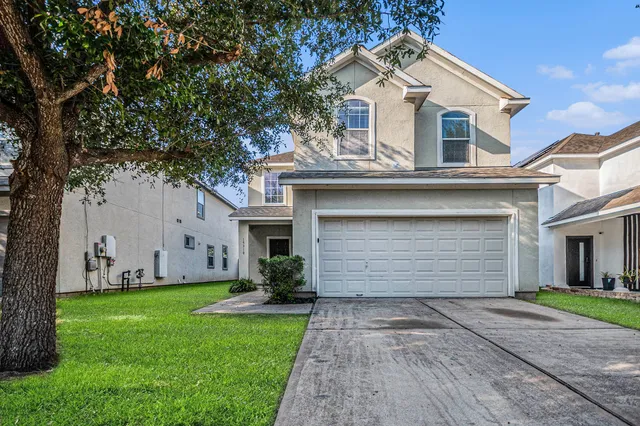 a front view of a house with a garden and yard