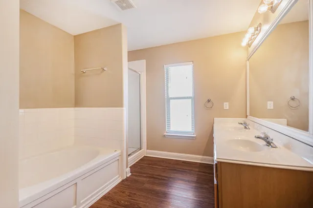 a bathroom with a tub sink and mirror