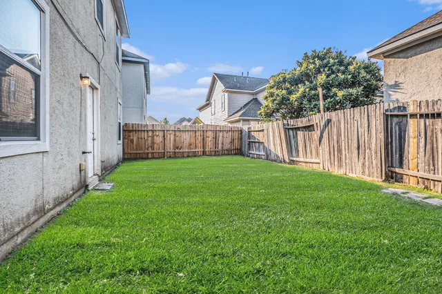 a view of a deck with a big yard and a large tree