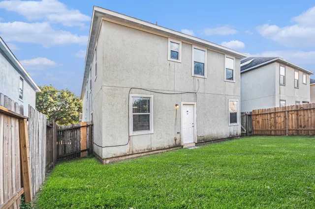 a view of backyard with barbeque grill potted plants and wooden fence