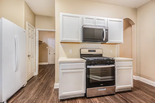 a kitchen with stainless steel appliances a stove a microwave and wood floors