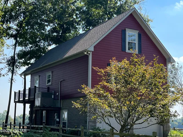 a view of a brick house next to a large tree