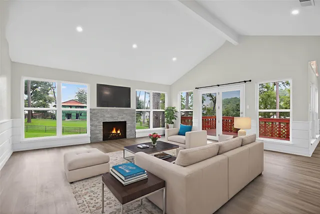 a living room with furniture a fireplace and a large window with balcony view