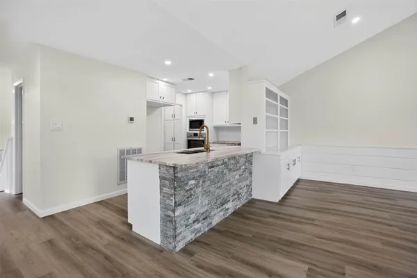 a kitchen with stainless steel appliances kitchen island wooden cabinets and fireplace