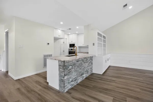 a kitchen with stainless steel appliances kitchen island wooden cabinets and fireplace