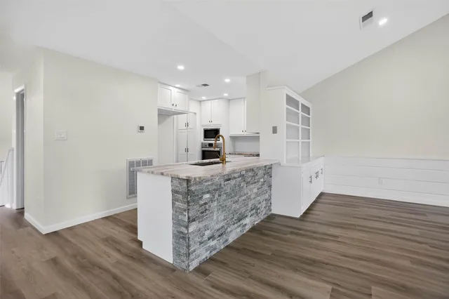 a kitchen with stainless steel appliances kitchen island wooden cabinets and fireplace