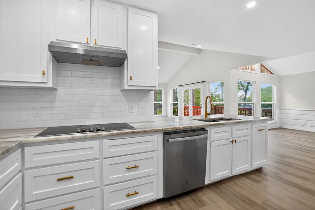 a kitchen with granite countertop a sink and cabinets