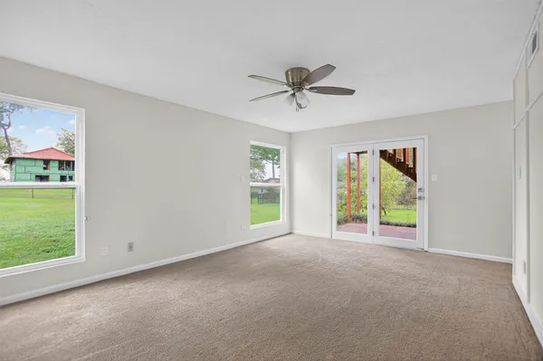 a view of an empty room with a window and a kitchen