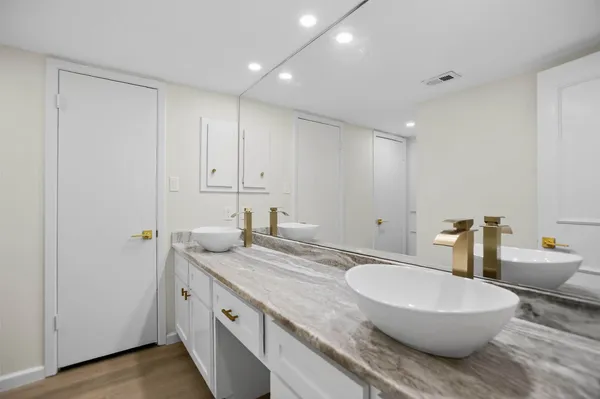 a bathroom with a granite countertop sink and a mirror