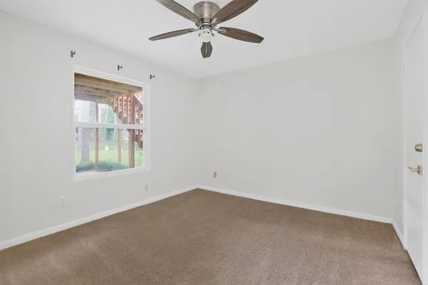 an empty room with a window and a fan