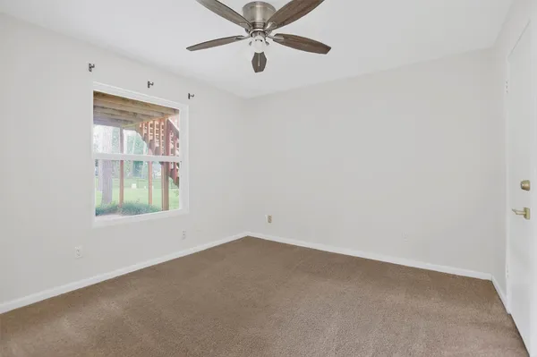 an empty room with a window and a fan