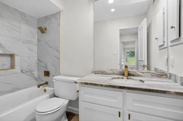 a bathroom with a granite countertop sink toilet and shower