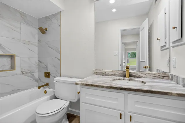 a bathroom with a granite countertop sink toilet and shower