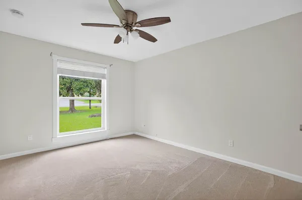 an empty room with a window and a fan