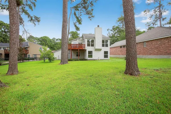 a view of a house with a big yard and large trees