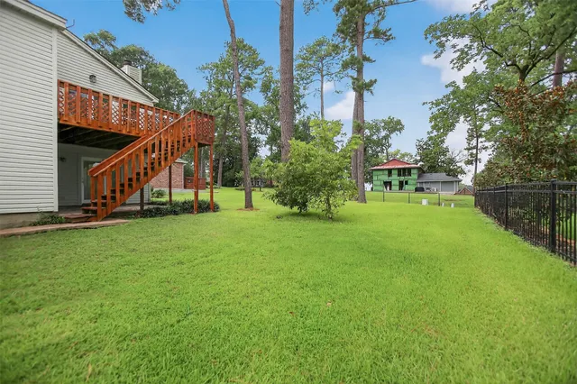 a view of an house with backyard and a tree