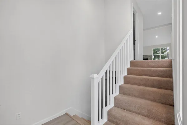 a view of staircase with lots of frames on wall and stairs