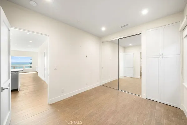 a living room with stainless steel appliances kitchen island granite countertop a refrigerator and cabinets