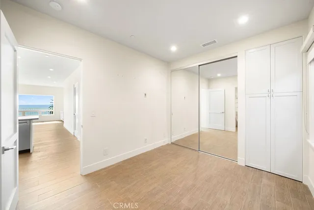 a living room with stainless steel appliances kitchen island granite countertop a refrigerator and cabinets