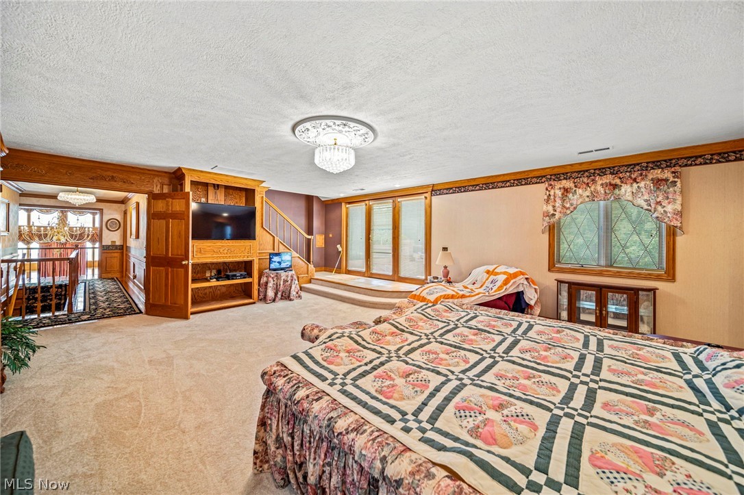 8801 Bunker Road Orwell, OH 44076 - Photo 40 of 50 Carpeted bedroom with a chandelier and a textured ceiling