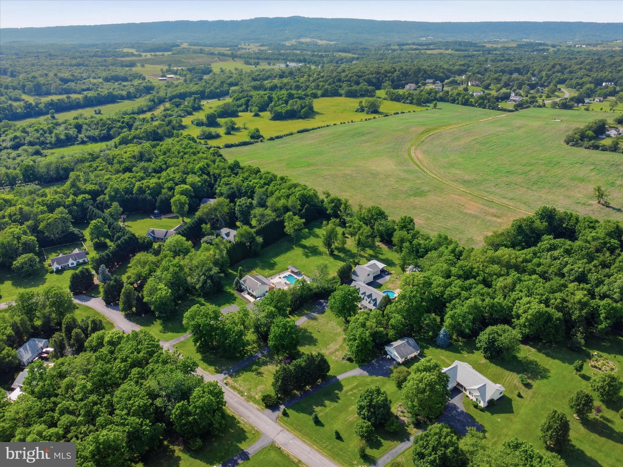 726 Doe Run Road Inwood, WV 25428 - Photo 61 of 68 an aerial view of green landscape with trees houses and mountain view