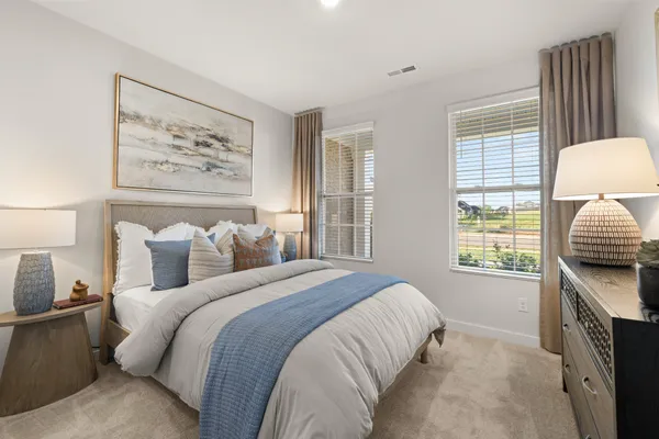 a bedroom with a bed and a flat tv screen on the dresser