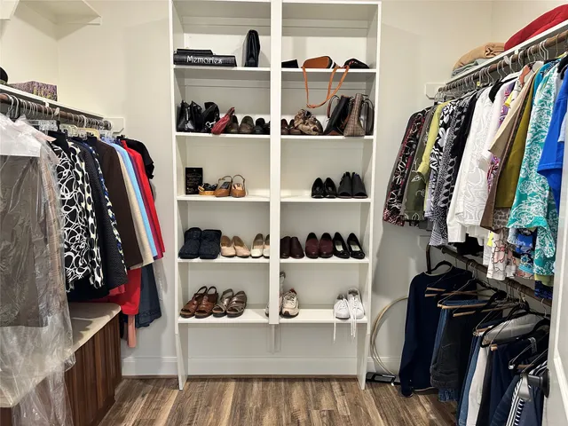 a view of walk in closet with clothes and shoes