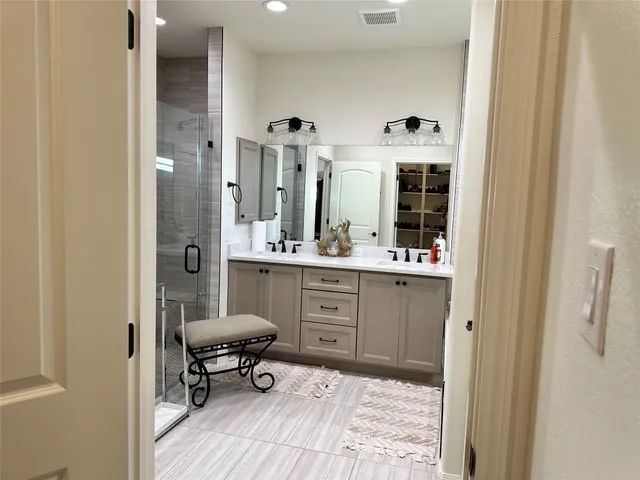 a bathroom with a sink mirror and a shower