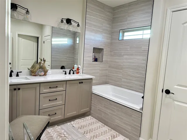 a bathroom with a bathtub sink and mirror